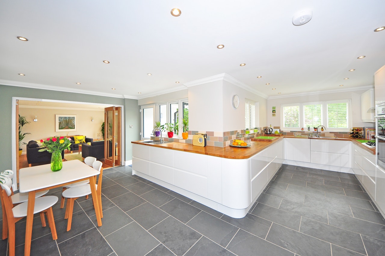 a white bright kitchen with wooden furniture